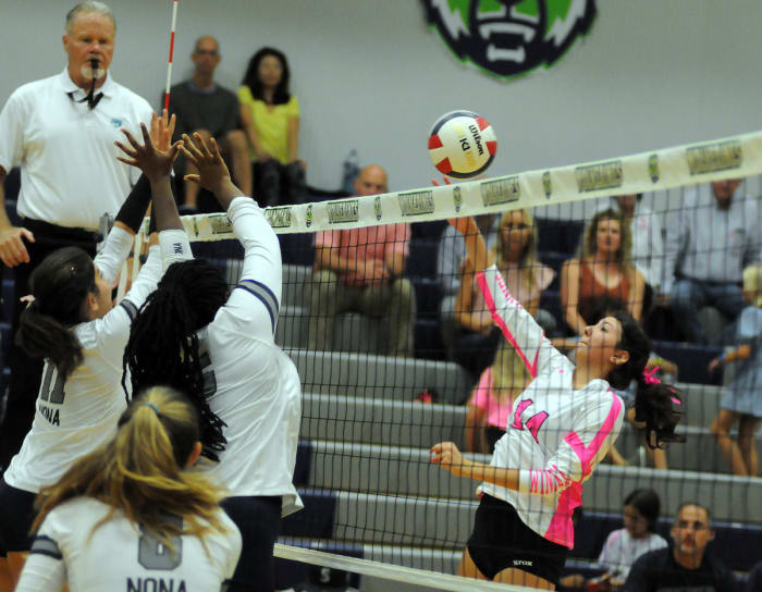 Windermere's Rebecca McGuire, right, goes for a kill against Lake Nona's Emma Gongora and Dakota Jean-Louis. McGuire had nine kills against Lake Nona.